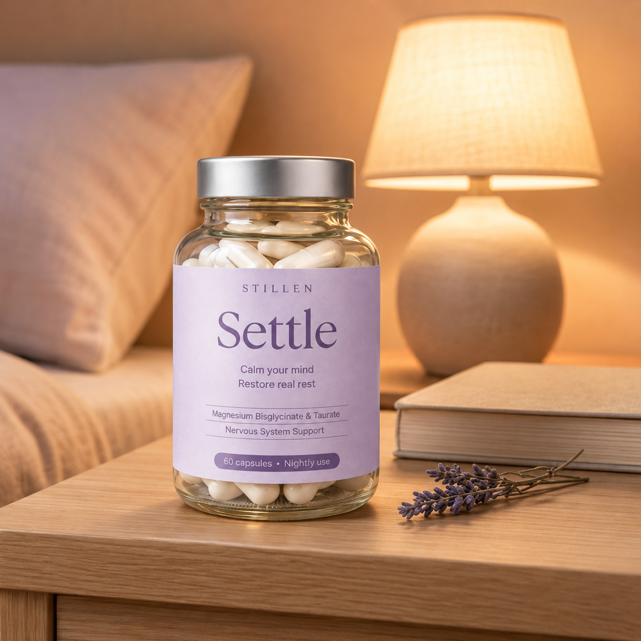 Jar of 'Settle' capsules by Stillen on a nightstand with a lamp and book in the background.