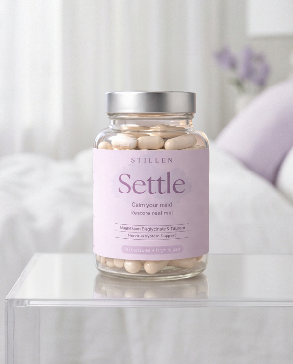 Jar of 'Settle' supplements on a nightstand with a blurred bedroom background