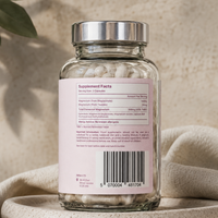 Glass supplement bottle with label on a textured surface showing elemental magnesium amount